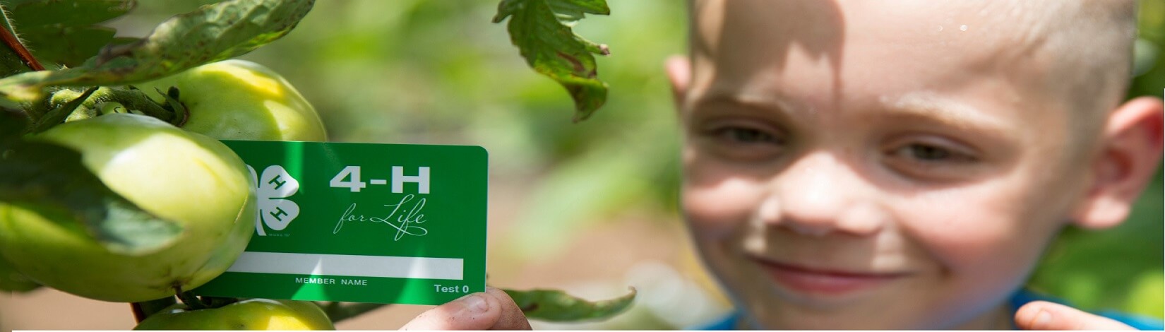 Child holding 4-H member card